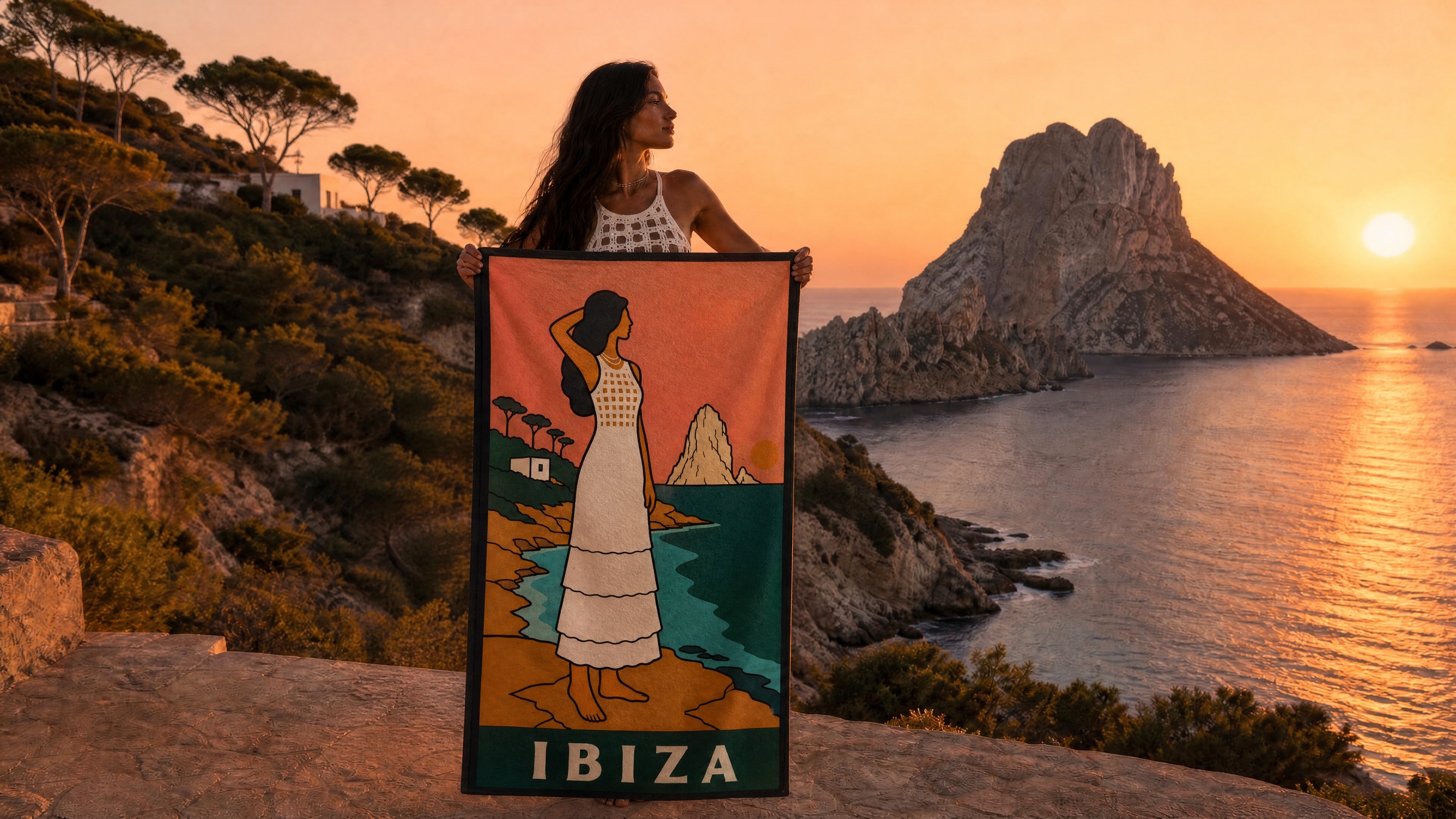 The IBIZA beach towel held open at sunset before Es Vedrà